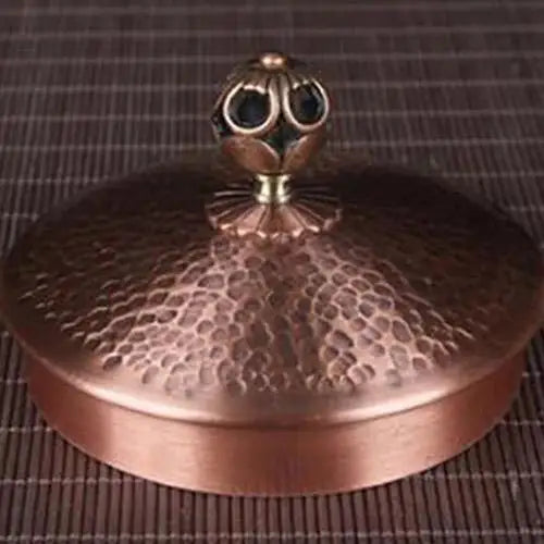 Antique copper kettle lid with classic knob, close-up view