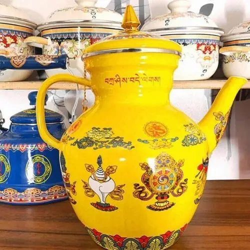 Close-up of hand-painted Buddhist symbols on yellow enameled porcelain kettle