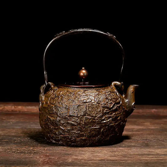 Cast iron teapot Ancient Rock style on wooden table with tea cup