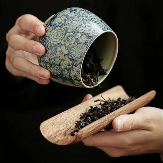Close-up of hand-painted cobalt blue ancestral motif on glazed ceramic tea canister