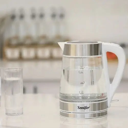 Pouring hot water from glass electric kettle
