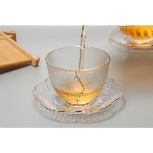 Clear glass saucer with a teacup and teapot