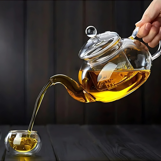 Clear glass teapot with removable infuser basket on table