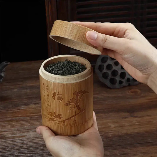Bamboo airtight tea storage box with loose leaf tea leaves beside it