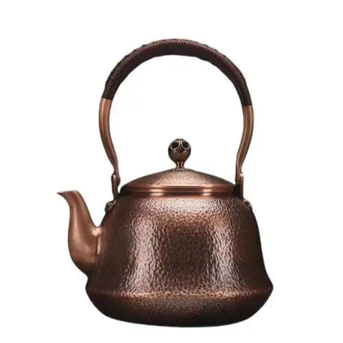 Vintage copper teapot with wooden handle on gas stove