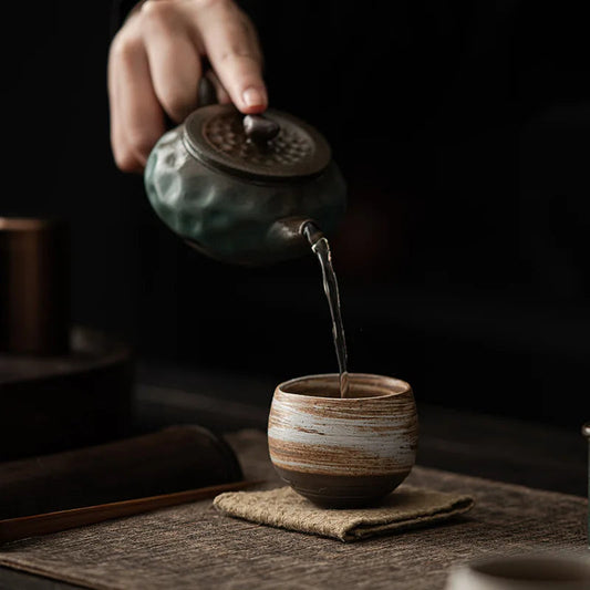Japanese stoneware tea cup showing raw clay exterior and glazed interior