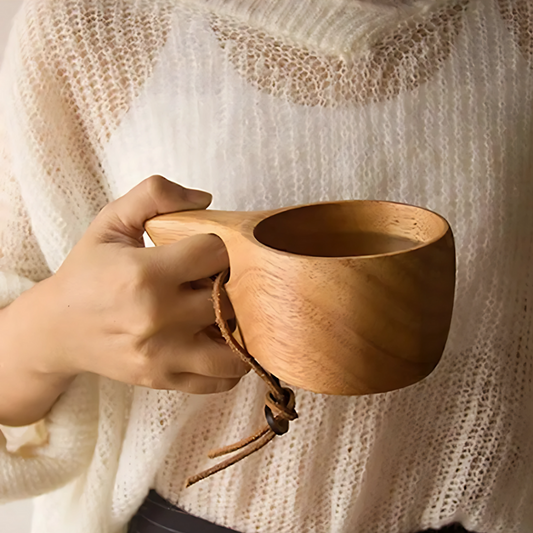 Kuksa wooden tea cup held in two hands warm drink