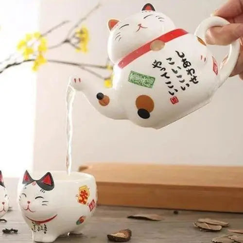 Maneki Neko teapot being used to pour hot tea into a cup