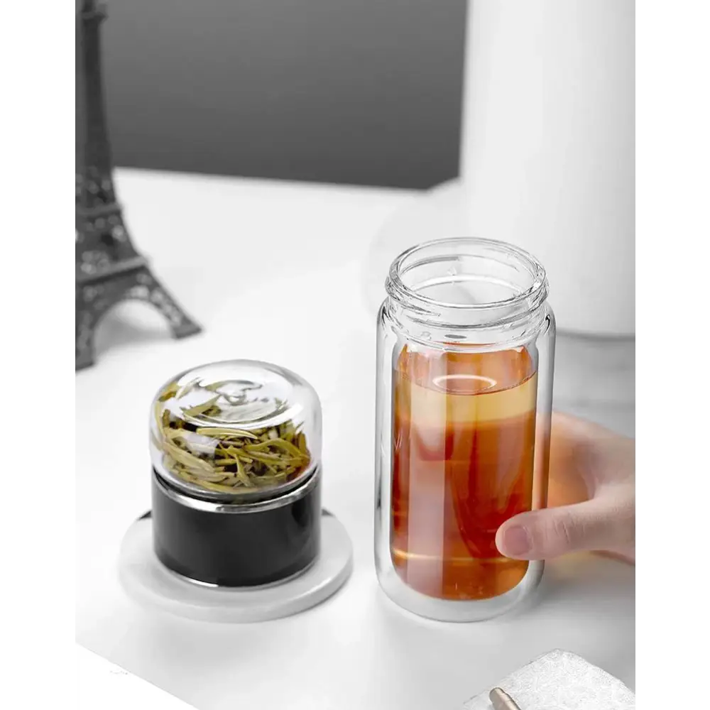 Portable tea infuser bottle with cup and tea leaves