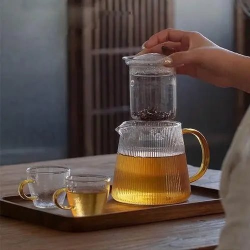 Removable stainless steel infuser basket from ribbed glass teapot