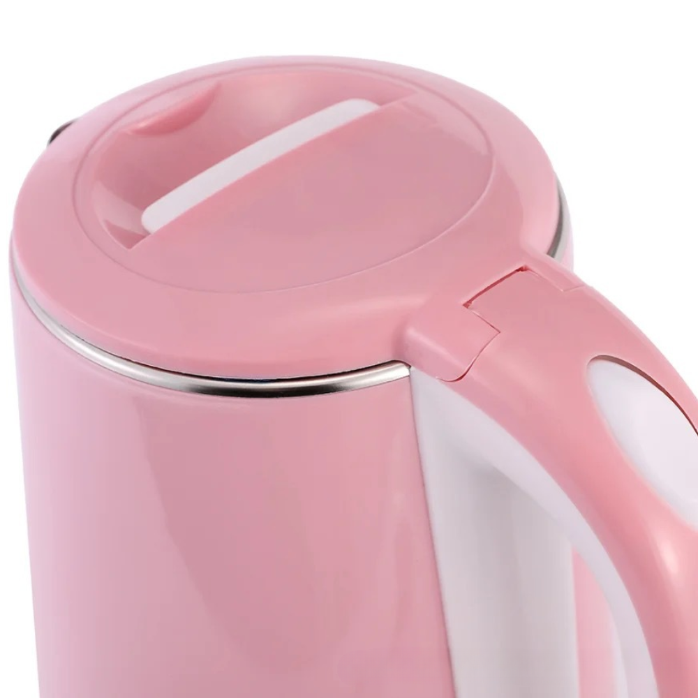 Rose electric kettle with cup of tea and cozy kitchen setting
