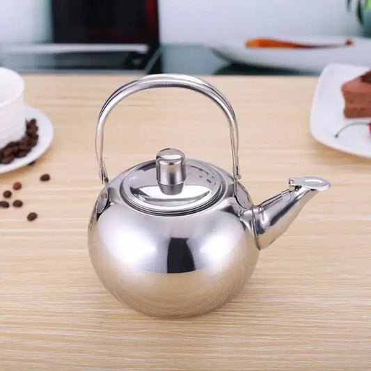 Stainless steel teapot 1 liter with infuser basket resting on a wood table