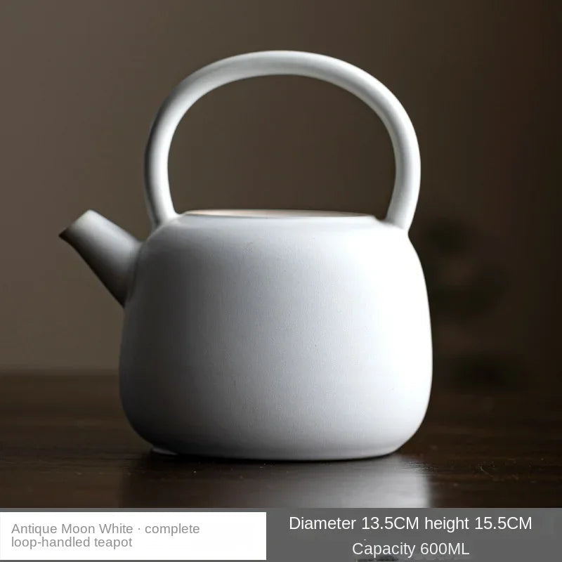 Elegant white Chinese ceramic teapot displayed on a rustic wooden shelf