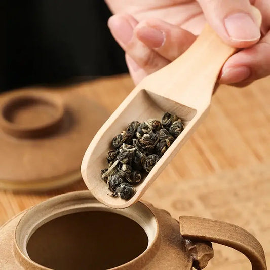 Wooden tea spoon for loose leaf tea on a rustic table