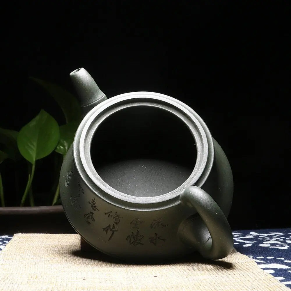 Yixing clay calligraphy teapot on wooden tea tray with gong fu cup