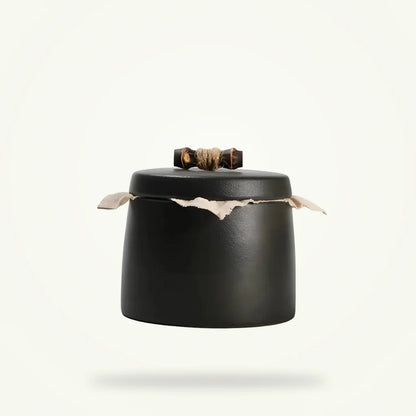 Antique ceramic tea canister with airtight lid on plain white background
