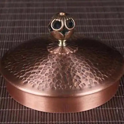 Antique copper kettle lid with classic knob, close-up view