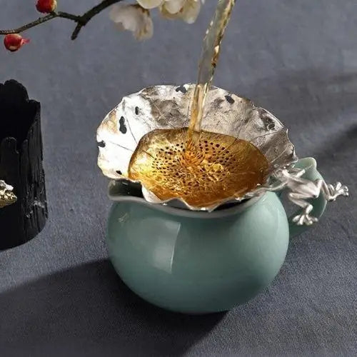Antique tea strainer in use over a cup