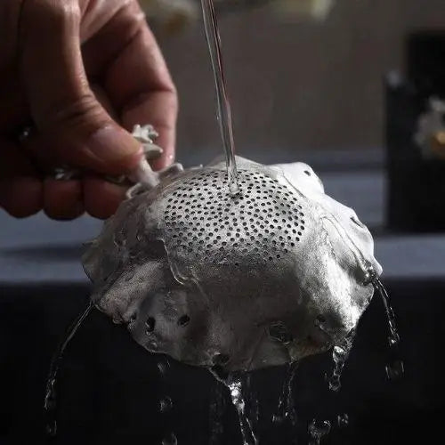 Cleaning antique tea strainer under water