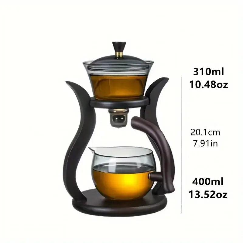 Automatic glass teapot tea infuser next to a brewed cup of tea