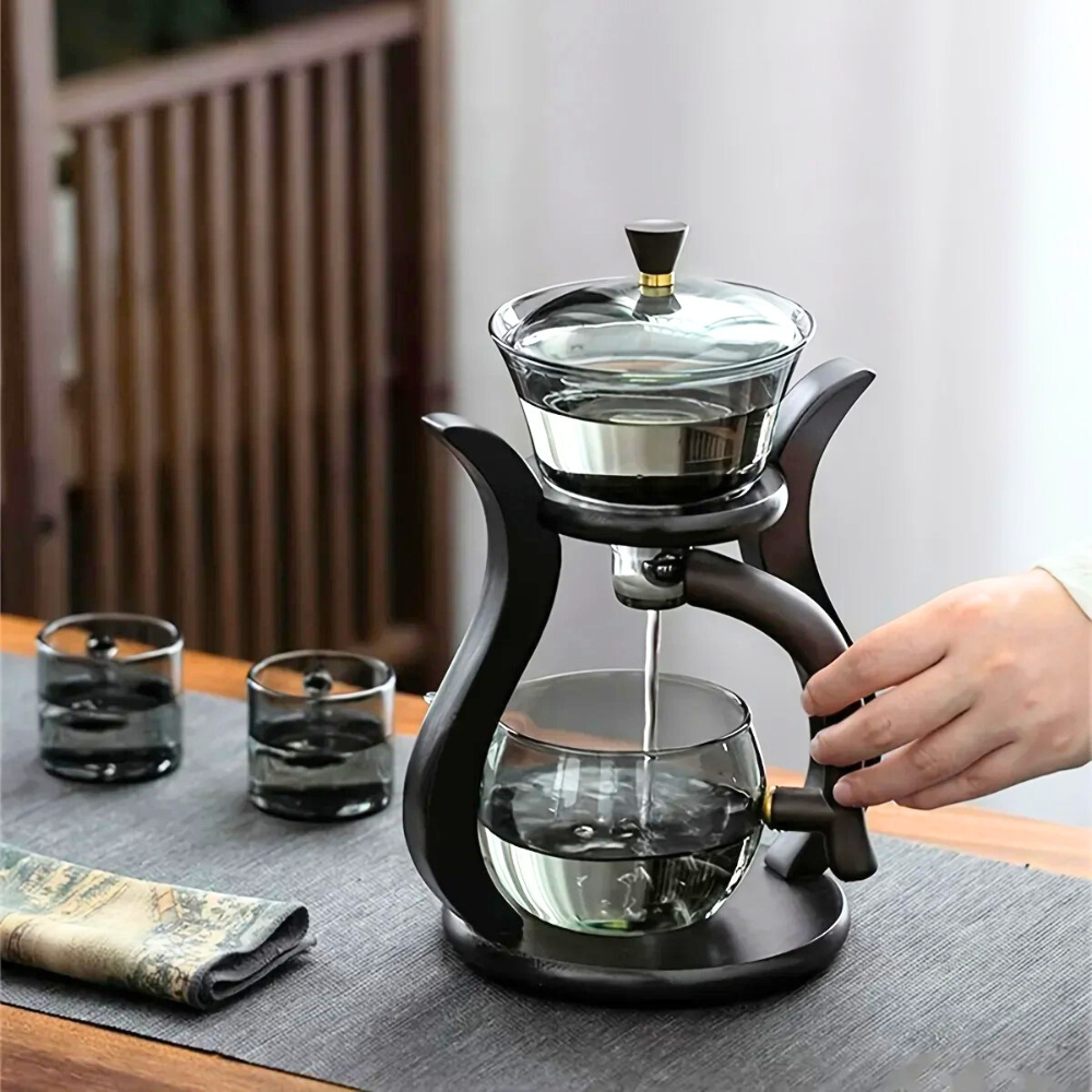 Automatic tea infuser glass teapot with loose leaf tea leaves nearby