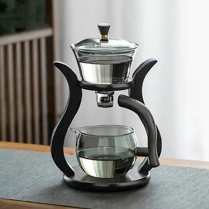 Automatic tea infuser with glass teapot and freshly brewed cup of tea