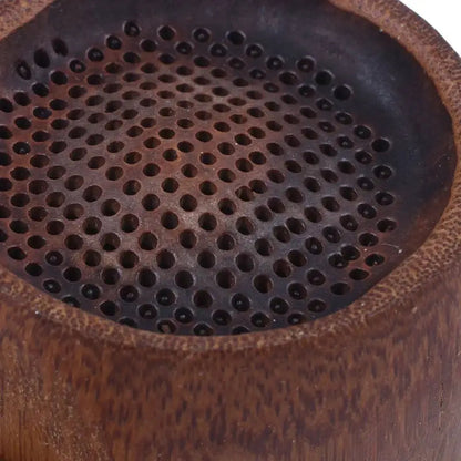 Bamboo tea infuser with green tea leaves nearby