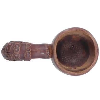 Bamboo tea infuser held in hand over a cup