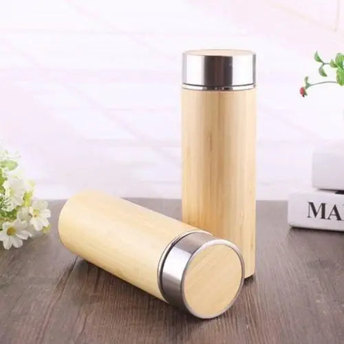 Bamboo tea thermos with stainless steel insulated bottle on wood surface