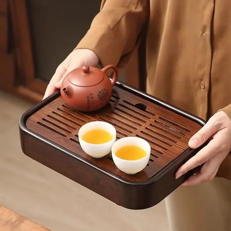 Bamboo tea tray holding a teapot and cups