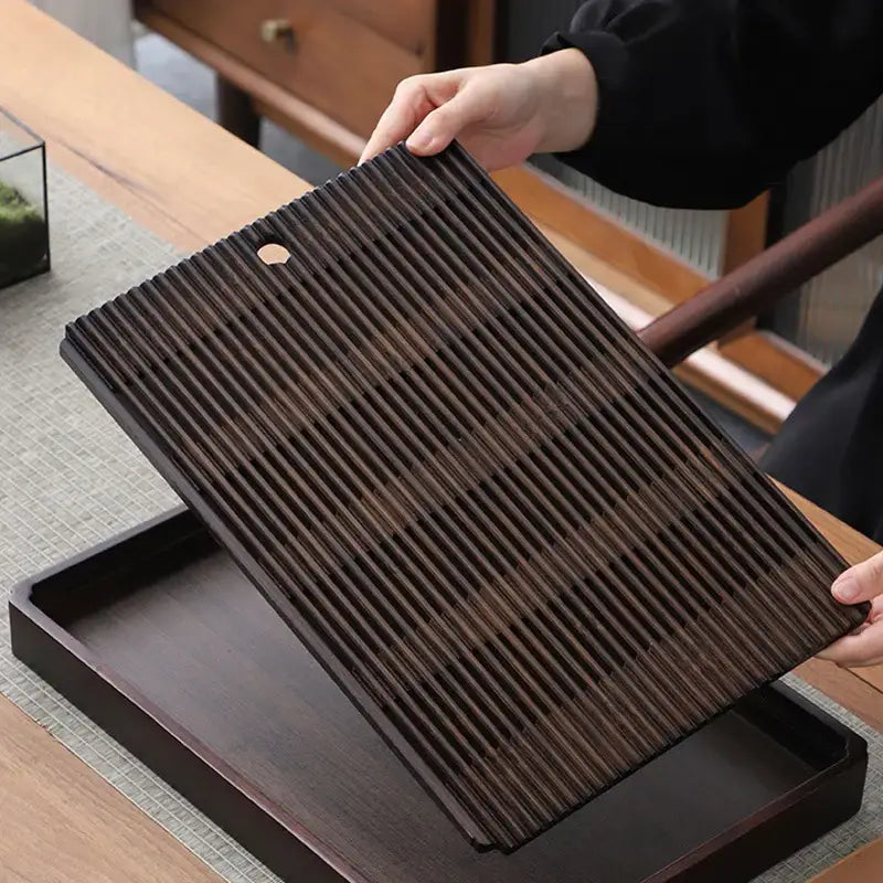 Bamboo tea tray on wooden table with tea accessories