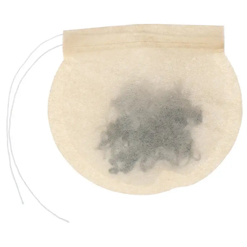Used compostable tea filter dropped into a compost bin after steeping