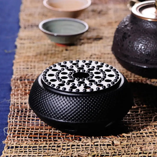 Cast iron teapot warmer supporting a ceramic teapot during a tea session