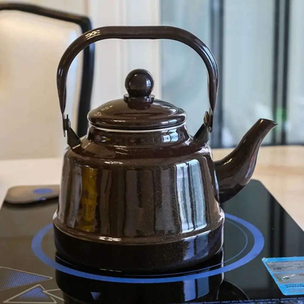 Black enamel teapot with steam rising