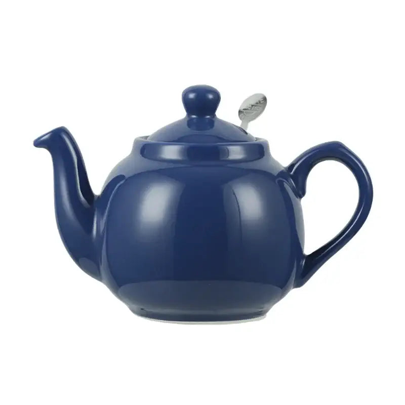 Blue ceramic teapot pouring tea into cup