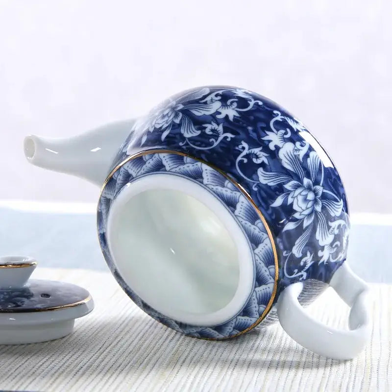Blue ceramic teapot with cup of tea