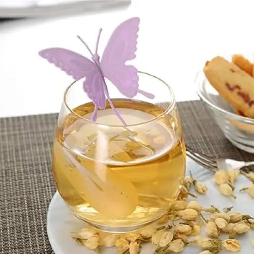 Violet butterfly tea infuser next to a teapot