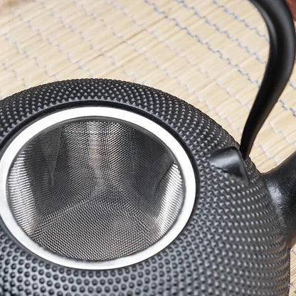 Cast iron teapot heating water directly on induction stovetop cooktop
