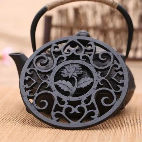 Cast iron teapot trivet on table with teapot