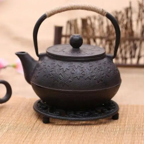 Close up of cast iron teapot trivet with flower design