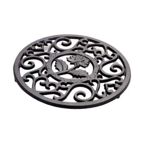 Cast iron trivet for teapot on wooden table