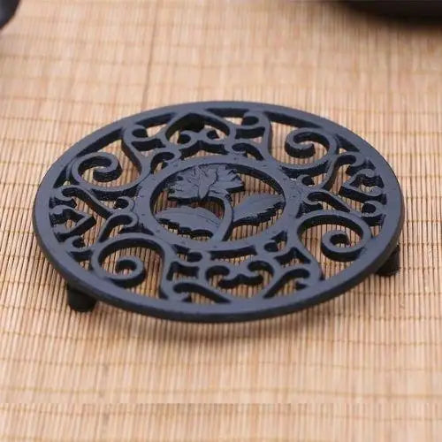 Teapot resting on cast iron trivet with steam
