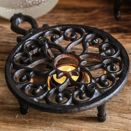 Cast iron tea warmer holding ceramic teapot during serving, warm light setting