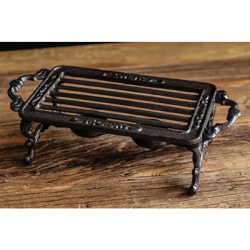 Cast iron teapot warmer stand design option 3, ornate forged iron detail on black background