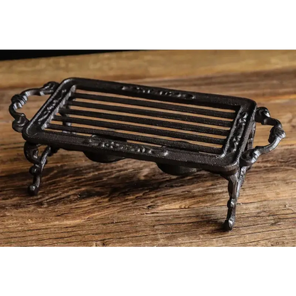 Cast iron teapot warmer stand design option 3, ornate forged iron detail on black background