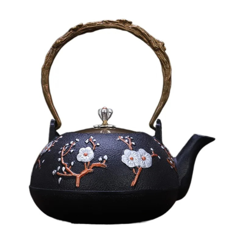 Cast iron bird teapot on wooden table with matching tea cup and loose leaf tea