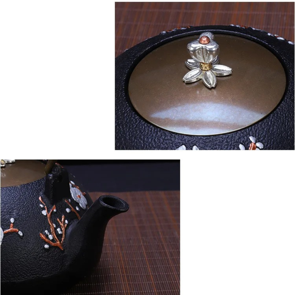 Cast iron bird teapot on tray beside cup and scattered loose leaf tea leaves