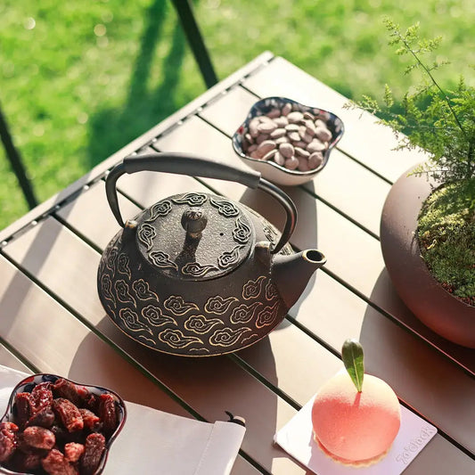 Handmade cast iron teapot with steam rising from spout