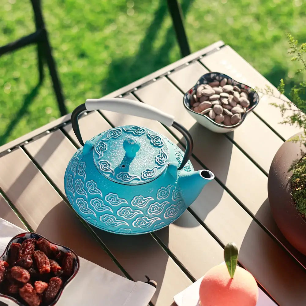 Cast iron teapot pouring tea into a cup
