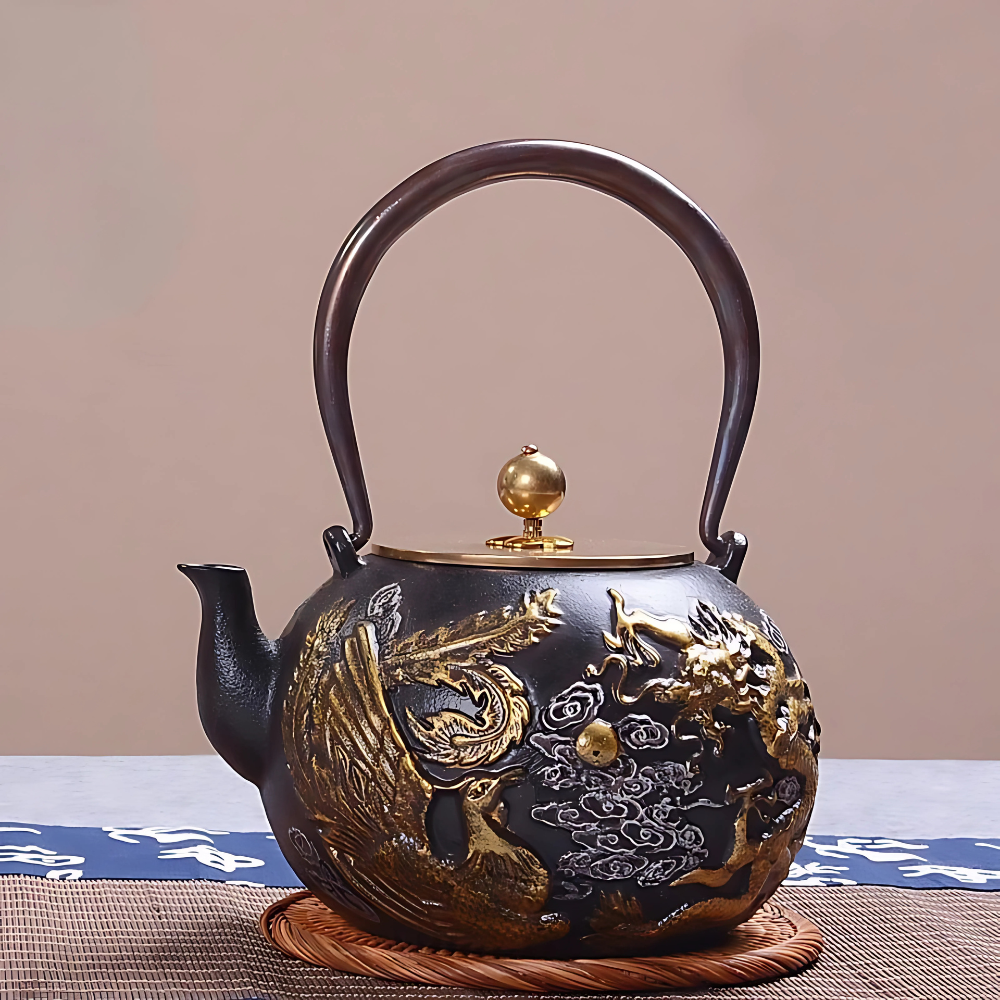 Close-up of phoenix and dragon gold motif on cast iron teapot